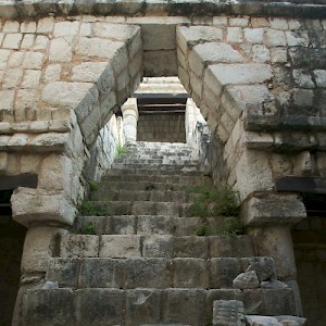 The distinctive Mayan arch beckons up a steep stairway on this temple under restoration at Chichen Viejo. <a href=></a>