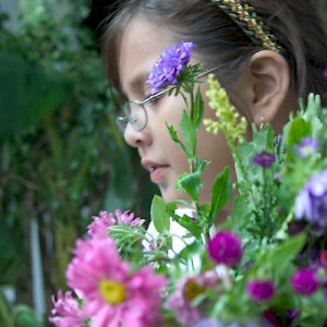 A young girl carrying flowers. <a href=></a>